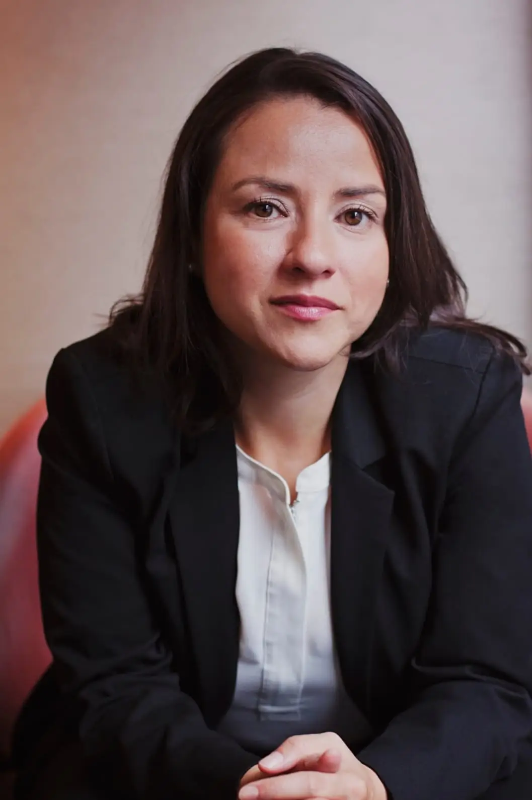 Portrait of a professional woman with dark hair wearing a black blazer and white blouse.